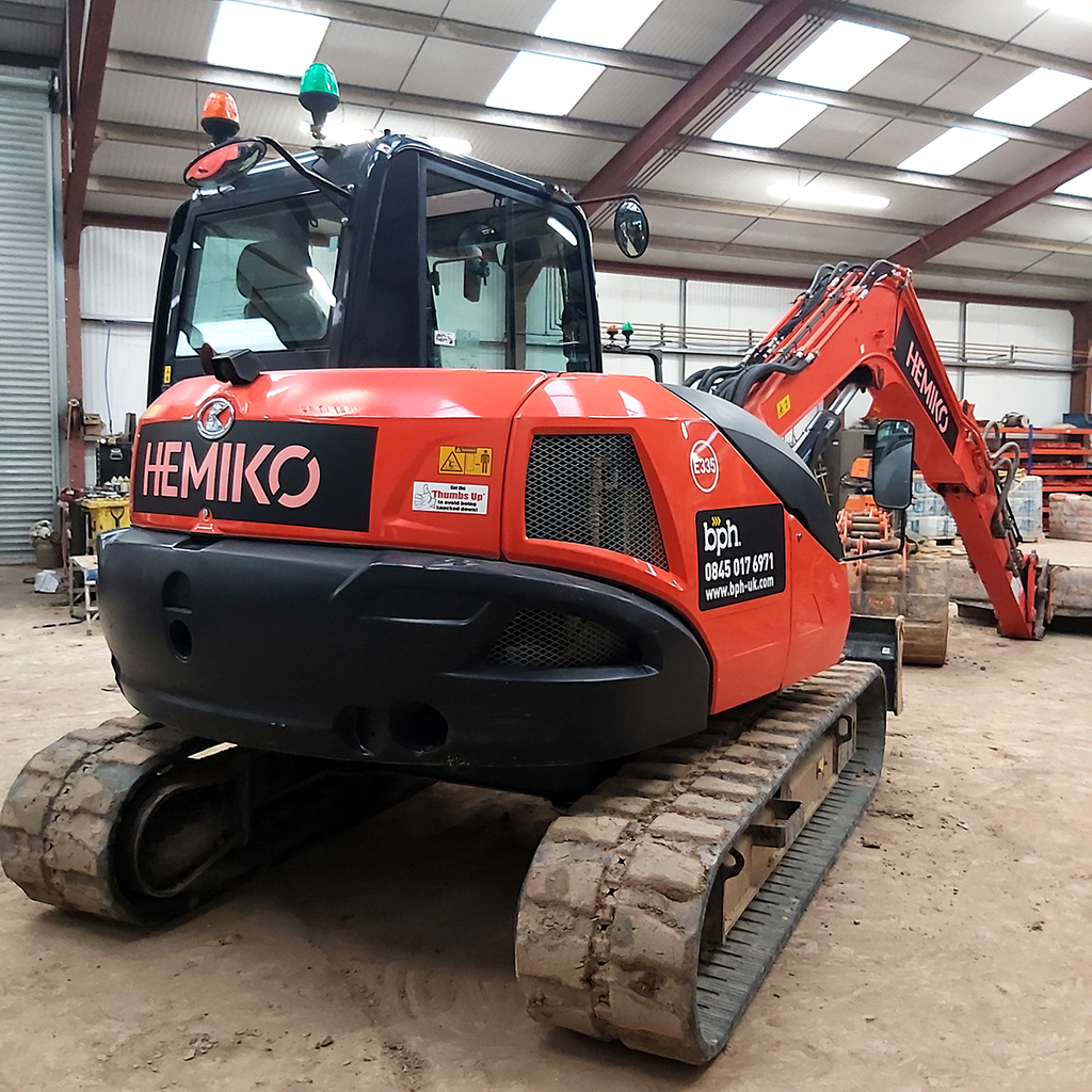 Construction excavator with custom Purple Signs vehicle graphics applied to the bodywork